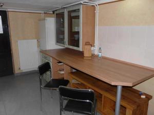 a kitchen with a wooden counter and two chairs at Ferienwohnung Winter in Lutherstadt Wittenberg