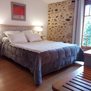a bedroom with a large bed with a stone wall at ma chambre d'hôtes à Rivesaltes in Rivesaltes