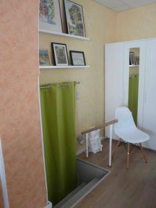ルターシュタット・ヴィッテンベルクにあるFerienwohnung Winterの緑のシャワーと白い椅子が備わる客室です。
