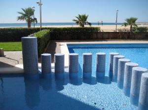 トラダンバーラにあるapartamentoのビーチ前の白い柱が並ぶプール