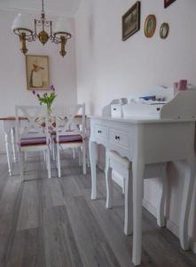 a room with a white desk and chairs and a table at Ferienwohnung Riemeyer in Lutherstadt Wittenberg +29 photos