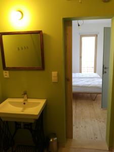 ein Badezimmer mit einem Waschbecken und ein Schlafzimmer mit einem Bett in der Unterkunft Kůlna in Brod nad Dyjí
