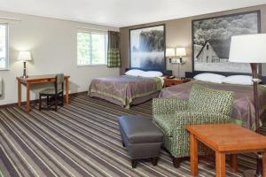 a hotel room with two beds and a desk at Super 8 by Wyndham Richlands/Claypool Hill Area in Pounding Mill