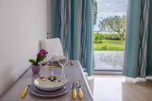 a table with a plate of food and wine glasses at Apartments Bella Vista in Umag