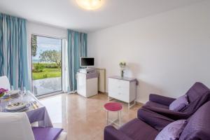 a living room with a purple couch and a tv at Apartments Bella Vista in Umag