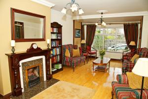 a living room with a fireplace and a mirror at Ashville House in Killarney