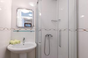 a white bathroom with a sink and a shower at Apartments Bella Vista in Umag +25 photos