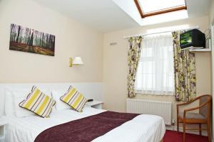 a bedroom with a white bed and a window at Ashville House in Killarney