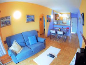 レスカラにあるVACAY Apartamento Tropicanaのリビングルーム(青いソファ付)、キッチン