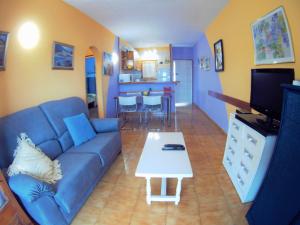 レスカラにあるVACAY Apartamento Tropicanaのリビングルーム(青いソファ、テーブル付)