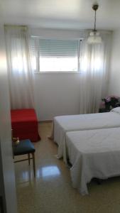 オ・グローベにあるApartamento San Vicenteのベッドルーム1室(ベッド2台、椅子、窓付)
