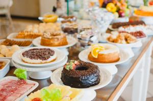 una mesa con diferentes tipos de repostería en los platos en Hotel Aladdin en Curitiba