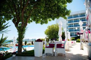 eine Terrasse mit einem Tisch und Stühlen sowie ein Gebäude in der Unterkunft Hotel Afrodita in Venus