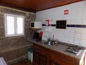 a kitchen with a counter and a sink and a window at Casa da Venda in Covide