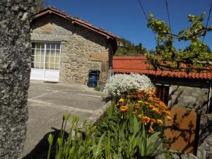 a garage with a white door and some flowers at Casa da Venda in Covide