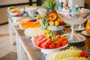 a buffet with plates of food on a table at Hotel Aladdin in Curitiba