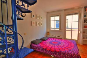 シッチェスにあるLlagut Apartment by Hello Homes Sitgesのベッドルーム(ピンクの傘付きのベッド1台付)