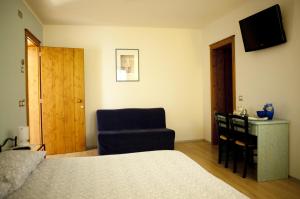 a bedroom with a bed and a chair and a desk at B&B Al Sole Di Cavessago in Belluno