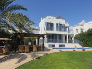 ein großes weißes Haus mit Pool und Hof in der Unterkunft Villa Victoria in Paphos City