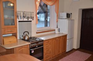 a small kitchen with a stove and a refrigerator at Dworek Mazurski Lizer in Stręgielek