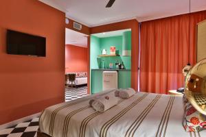 a bedroom with a bed with orange walls and a television at Cubanito Ibiza in San Antonio