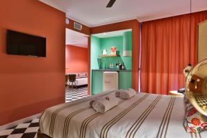 1 dormitorio con 1 cama con paredes de color naranja y TV en Cubanito Ibiza, en San Antonio