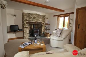 a living room with a couch and a fireplace at Jacks Cottage in Totnes