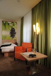 a hotel room with a couch and a table and a bed at Hotel Ratskeller in Salzgitter