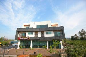 a white building with a black roof at Seong Ge Dol Pension in Seogwipo