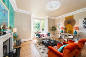 a living room with orange furniture and a fireplace at 3 Eskbank Terrace in Dalkeith