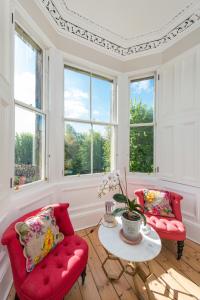 a living room with two red chairs and a table at 3 Eskbank Terrace in Dalkeith