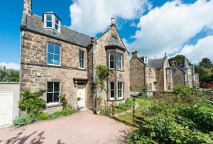 an old stone house with a gate in front of it at 3 Eskbank Terrace in Dalkeith