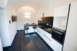 una cucina con armadietti bianchi e pavimento nero di The House On The River a Bosa