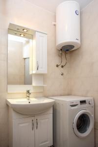 La salle de bains est pourvue d'un lavabo et d'un lave-linge. dans l'établissement Koi Seaview apartment, à Herceg-Novi