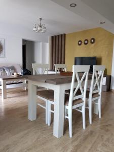 a dining room with a white table and chairs at apartament 2 camere ultracentral in Râmnicu Vâlcea