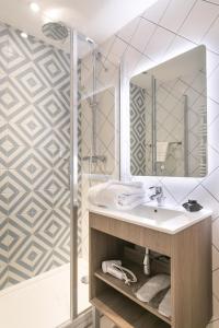 La salle de bains est pourvue d'un lavabo et d'une douche. dans l'établissement The Deck Hotel by Happyculture, à Nice