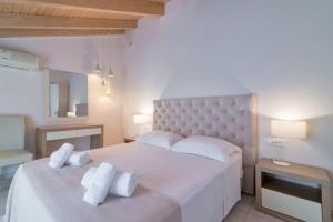 a bedroom with a large white bed with towels on it at Edelweiss Hotel in Argasi
