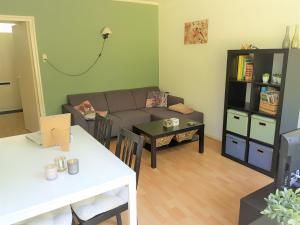 sala de estar con sofá y mesa en Bungalow Hartje Veluwe, en Otterlo