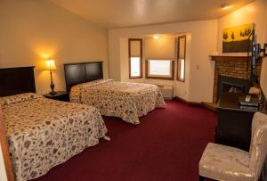 a hotel room with two beds and a fireplace at Hilltop Inn Broomfield Denver in Broomfield