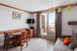 a living room with a table and a couch at Residence Les Bergers - maeva Home in L'Alpe-d'Huez