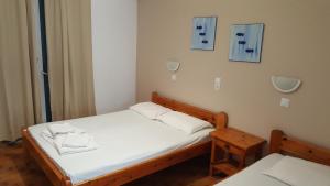 パリキアにあるAratos Hotelの小さなベッドルーム(白いシーツ付きのベッド1台付)