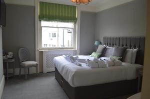Un dormitorio con una cama grande con dos animales de peluche. en The Crown Pub & Guesthouse, en Londres