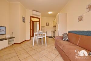 een woonkamer met een bank en een tafel bij Appartamento Romantica in Manerba del Garda