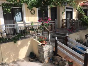 a house with a tree in a pot in front of it at Studios on the Beach in Skala Sotiros