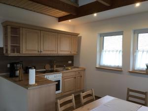 a kitchen with wooden cabinets and a table and a stove at Gut Fischer in Pomssen