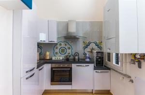 a kitchen with white cabinets and a stove at B&B Le Marinelle in Salerno