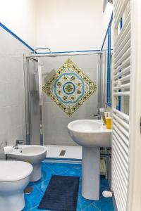 Un baño con dos lavabos, un inodoro y una ducha. en B&B Le Marinelle, en Salerno