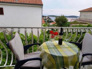 stół z butelką wina i kwiatami na balkonie w obiekcie Tanya-Apartments and Rooms w Hvarze