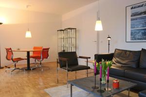 a living room with a couch and a table and chairs at Premium Apartment Universities/Arts District in Munich