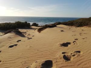 una playa con huellas en la arena y el océano en B&B S'Apposentu en Arbus